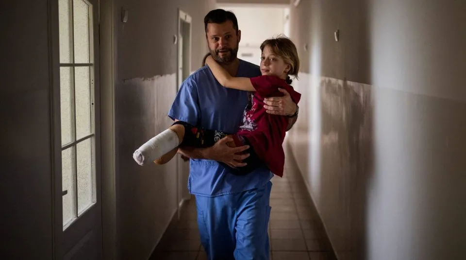 Хірург, який несе на руках поранену дівчинку з Краматорська. Фото: AP/Emilio Morenatti