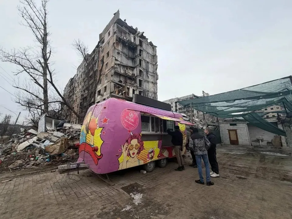Вагончик з шаурмою на фоні зруйнованого будинку в Авдіївці