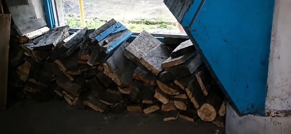 Дрова складені у підʼїзді будинку в окупованій Тошківці
